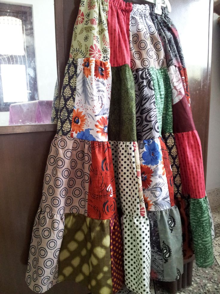 a multicolored skirt hanging on the wall in front of a mirror and door