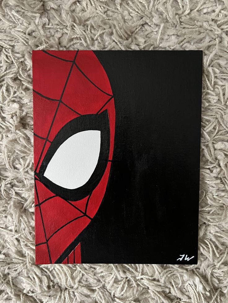 a close up of a painting on a carpet with a spiderman face painted on it