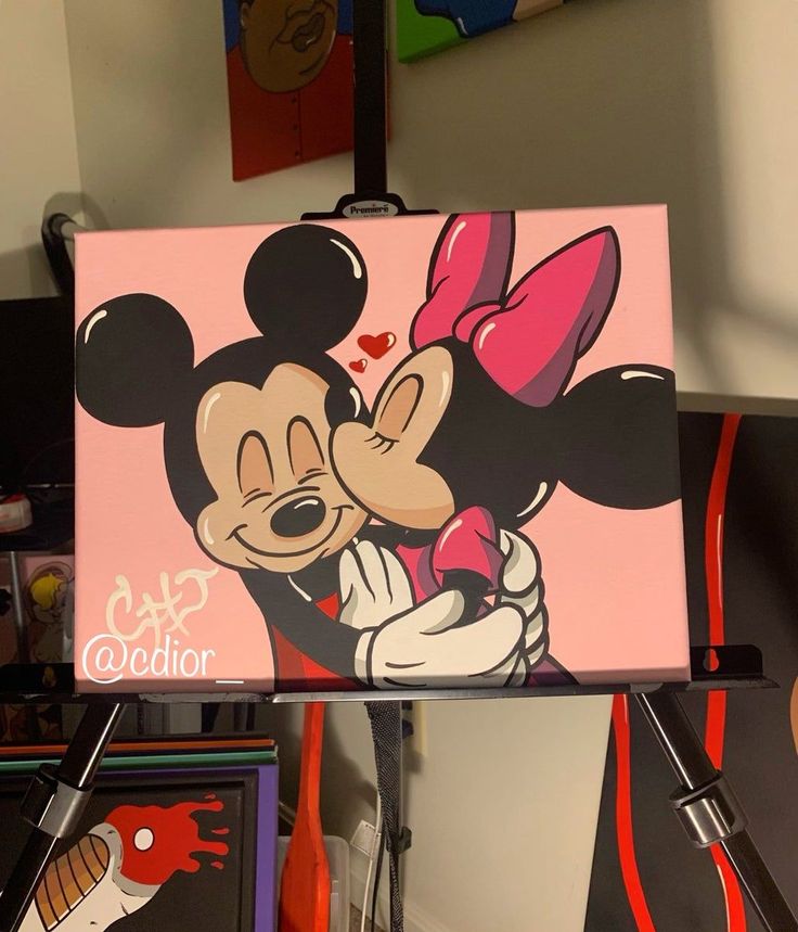 a painting of mickey and minnie kissing each other in front of some paintings on the wall