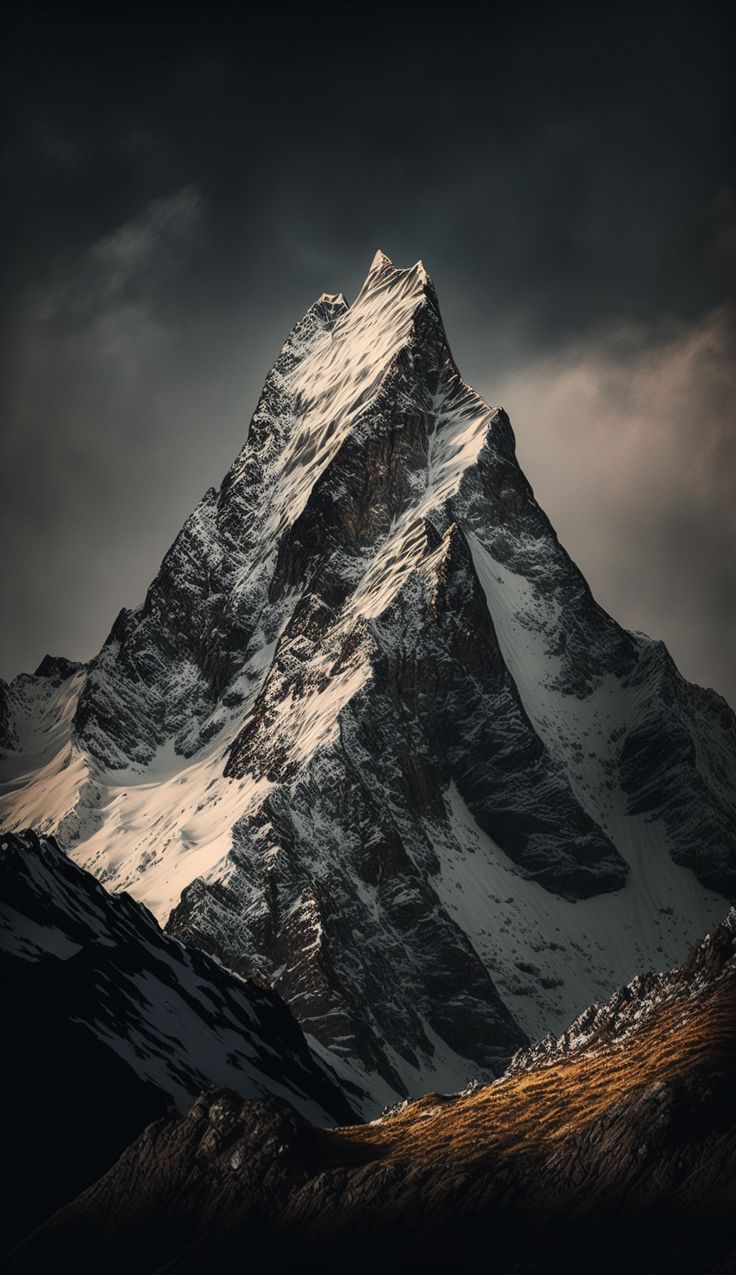 a snow covered mountain with dark clouds in the background