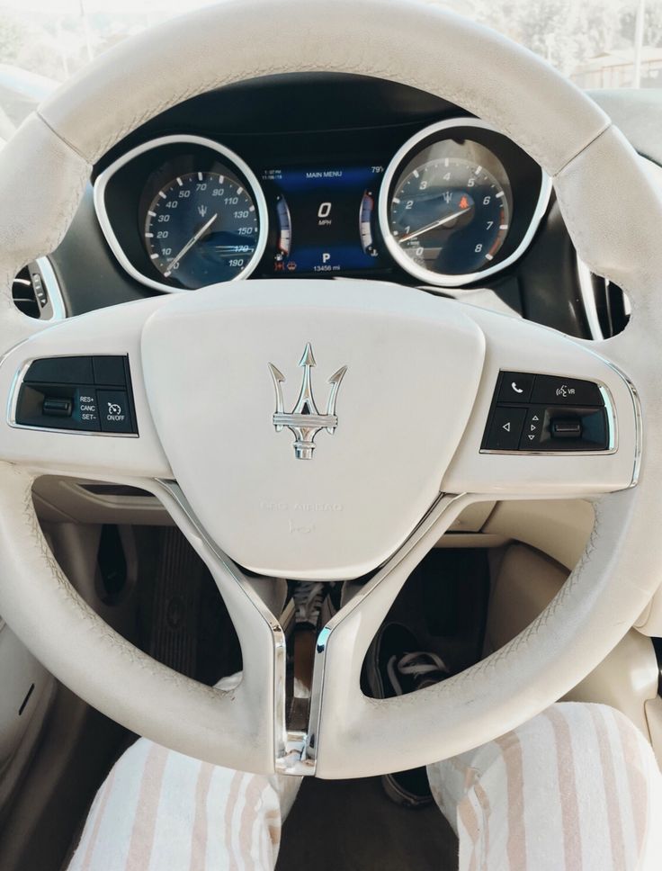 the interior of a car with steering wheel and gauges