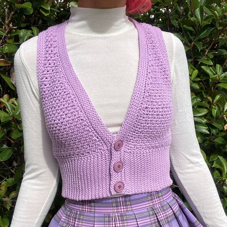 a mannequin wearing a purple sweater and plaid skirt