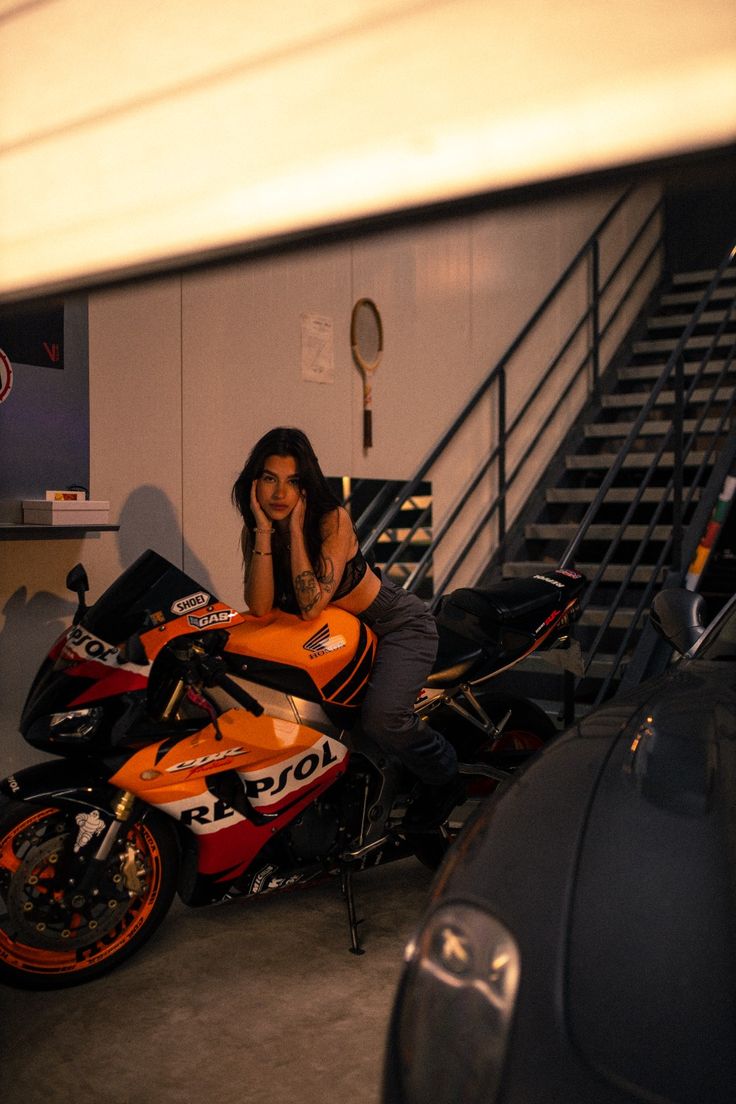 a woman sitting on top of a motorcycle in a garage