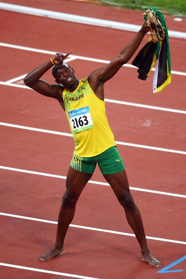 a male athlete holding his arms up in the air