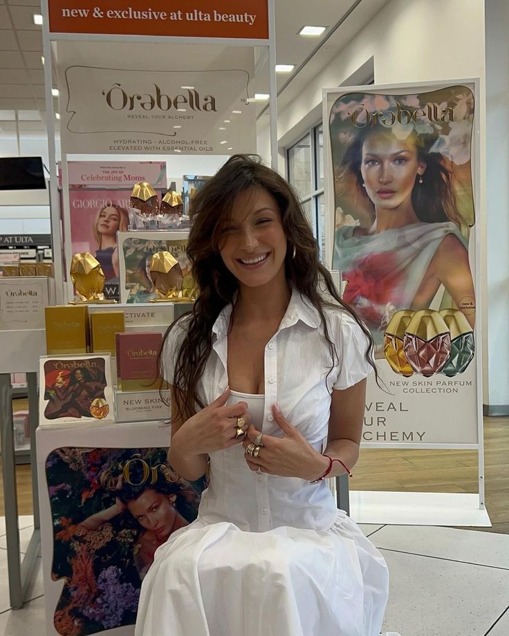 a woman sitting on top of a white chair in front of a store display case