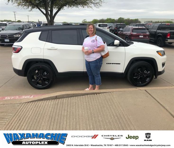 a woman standing next to a white jeep