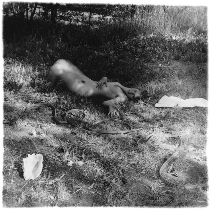 a naked man laying on the ground with his head down
