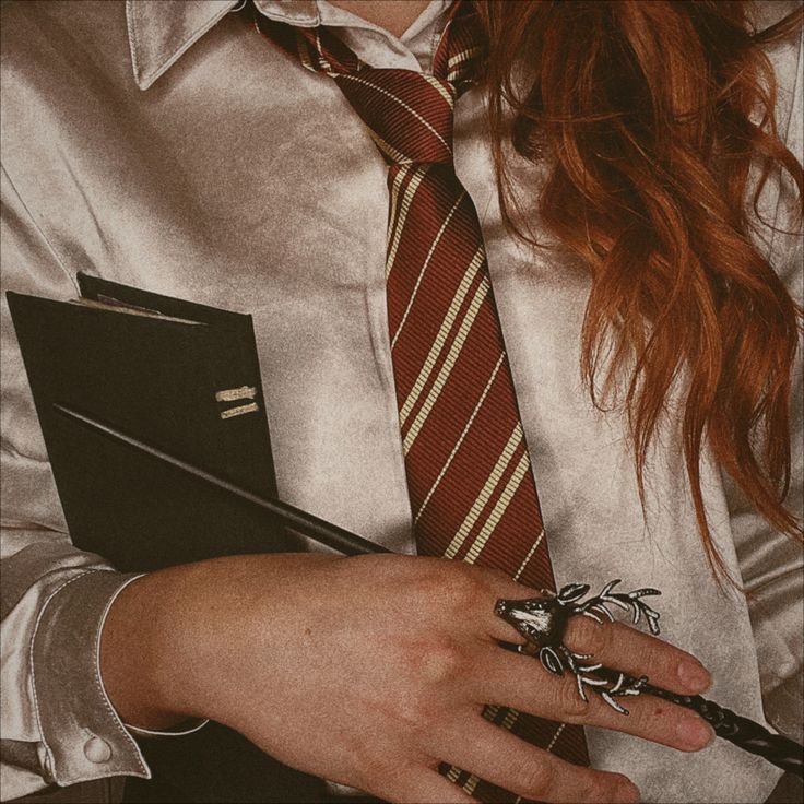 a close up of a person wearing a tie and holding a binder with an insect on it