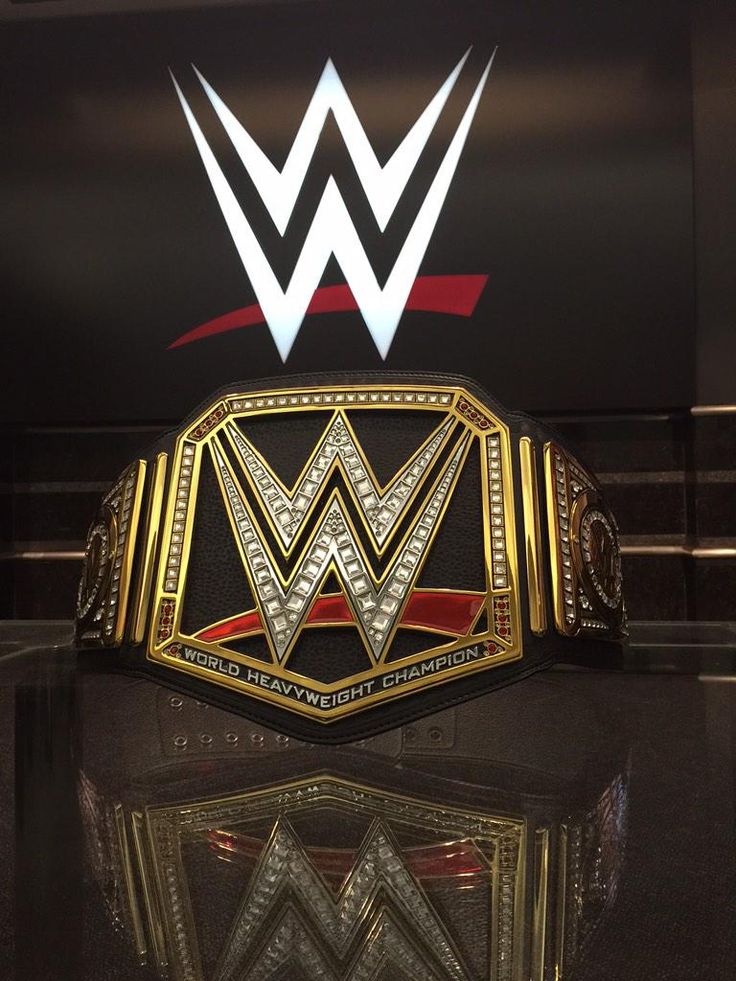 the wwe logo is displayed on top of a wrestling belt in front of a mirror
