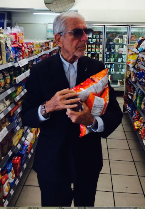 an older man in a suit and sunglasses is holding a bag with food on it