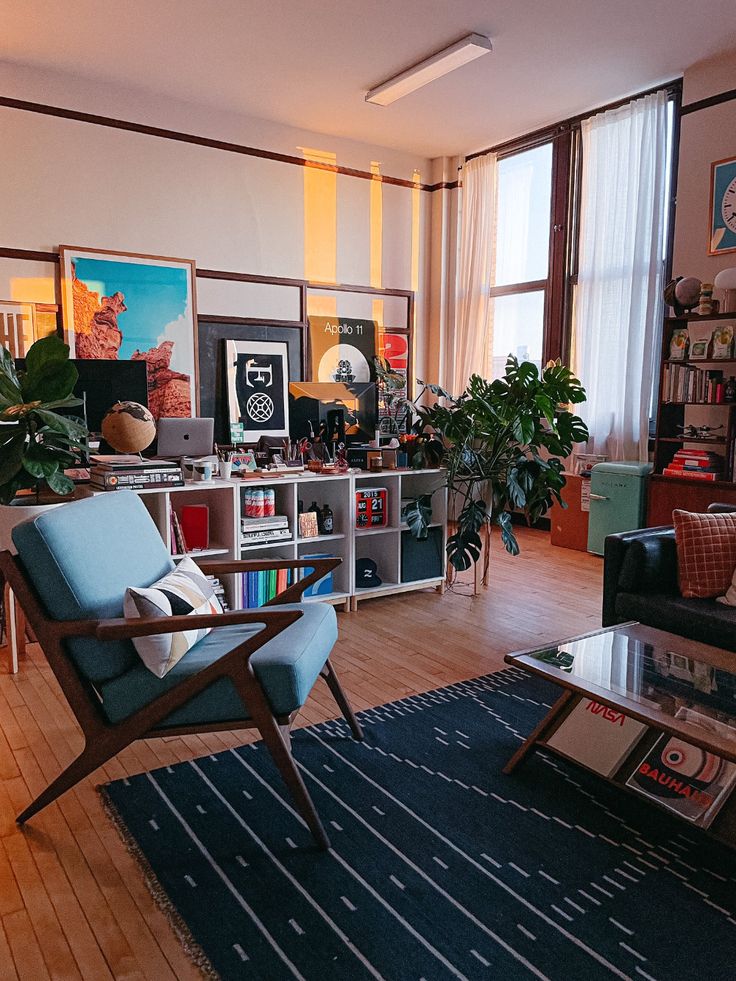 a living room filled with furniture and lots of plants on top of a hard wood floor