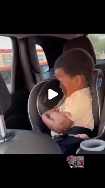 a little boy sitting in the back seat of a car