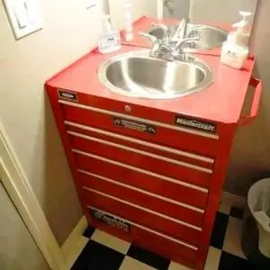 a bathroom with a sink, mirror and checkerboard flooring on the walls