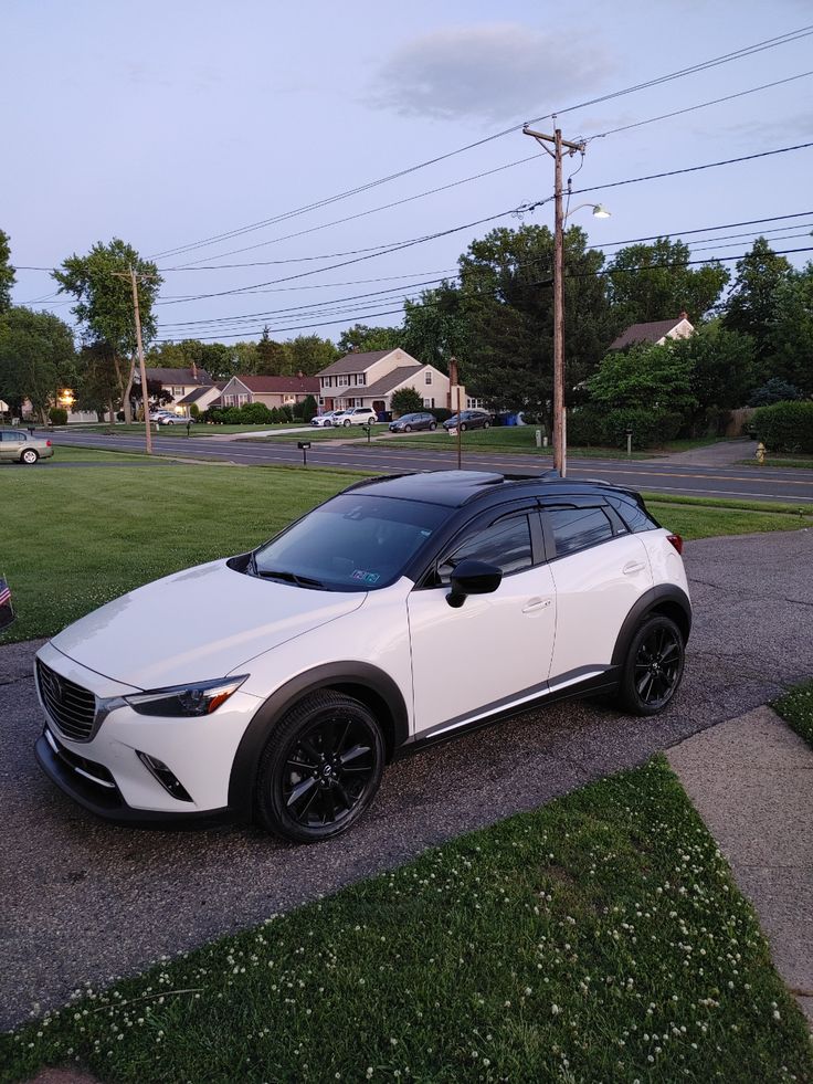 a white car is parked on the side of the road