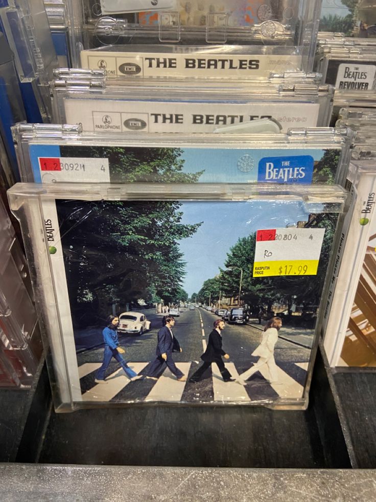 the beatles album covers are stacked on top of each other in a store display case