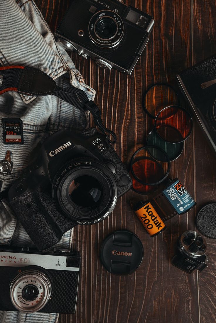 a camera, lens and other items on a wooden table next to each other for photography