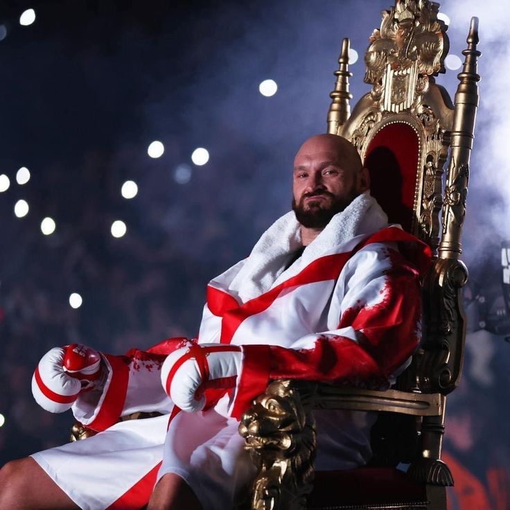 a man sitting on top of a golden throne in front of a crowd at a sporting event