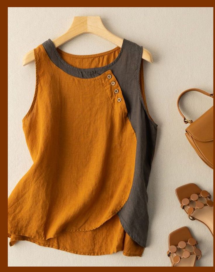 an orange and grey top sitting on top of a wooden hanger next to shoes