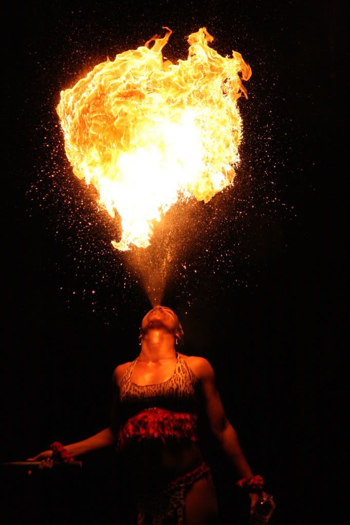 a woman is standing in front of a fire ball