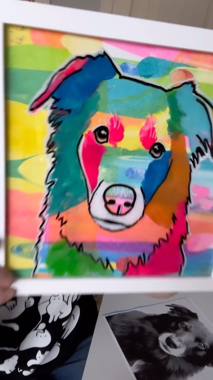 a person holding up a painting with a dog on it