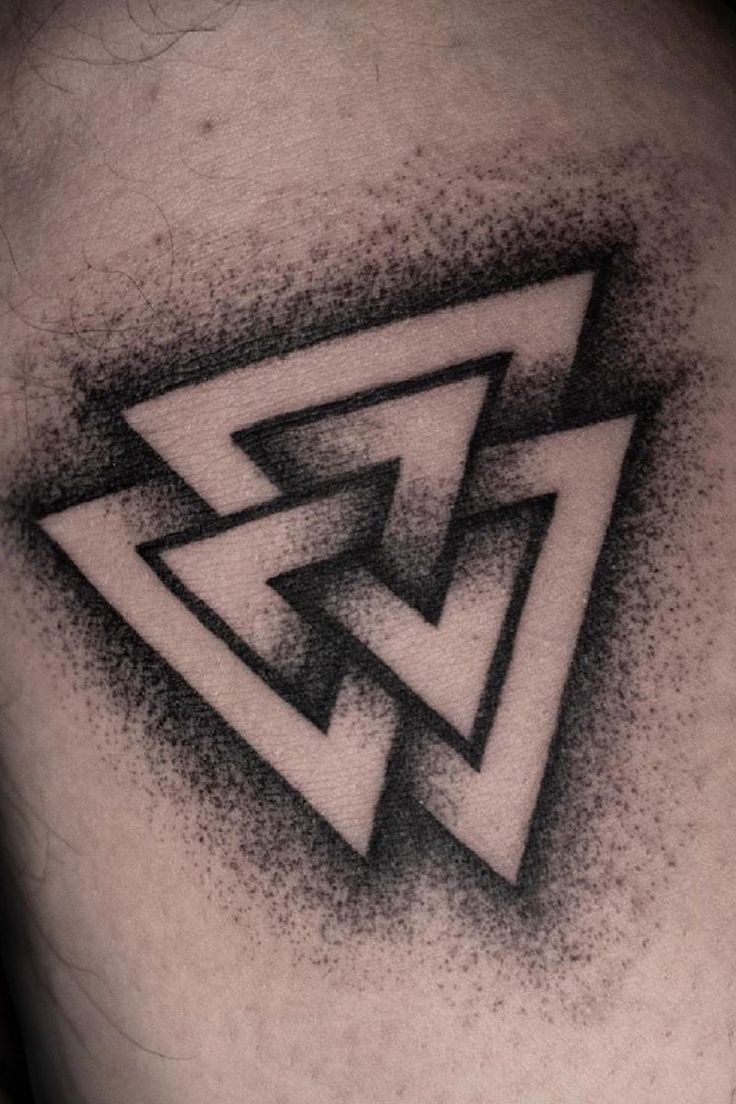 a black and white photo of a triangle tattoo