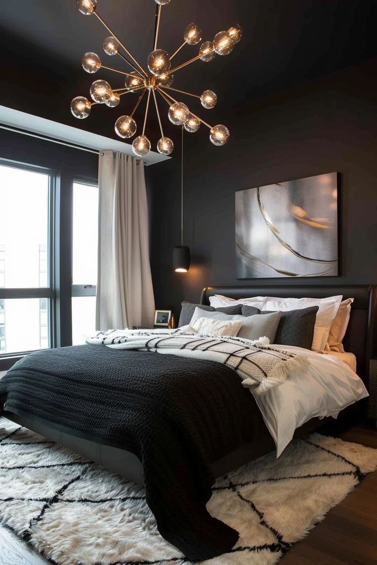 a bedroom with black walls, white and gray bedding and a chandelier