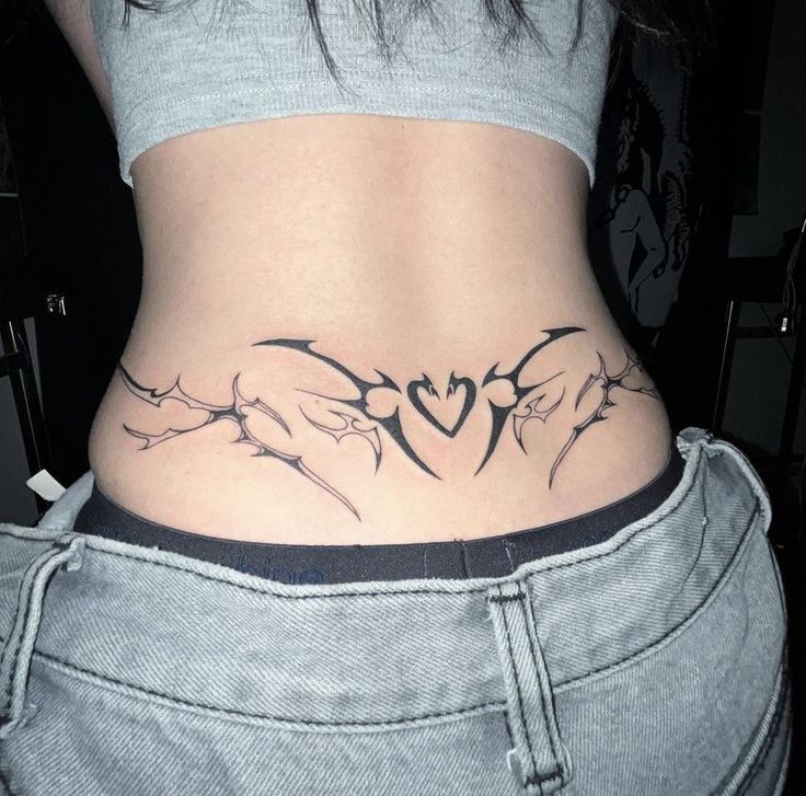 a woman's lower back tattoo with birds and hearts on her stomach, in black ink
