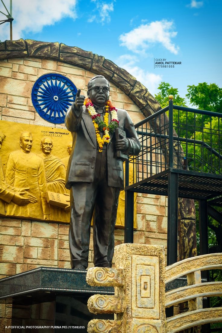 a statue of a man with a wreath around his neck stands in front of a building