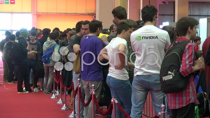 a group of people standing around each other with rackets in their hands and looking at something on the wall