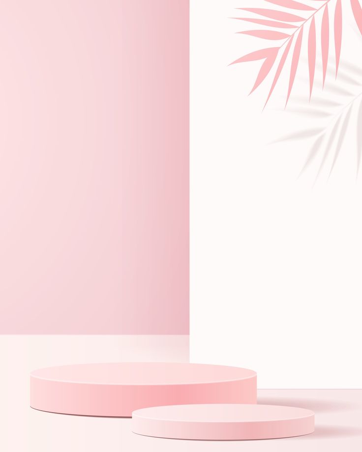 two round pink plates sitting on top of a white table next to a palm leaf