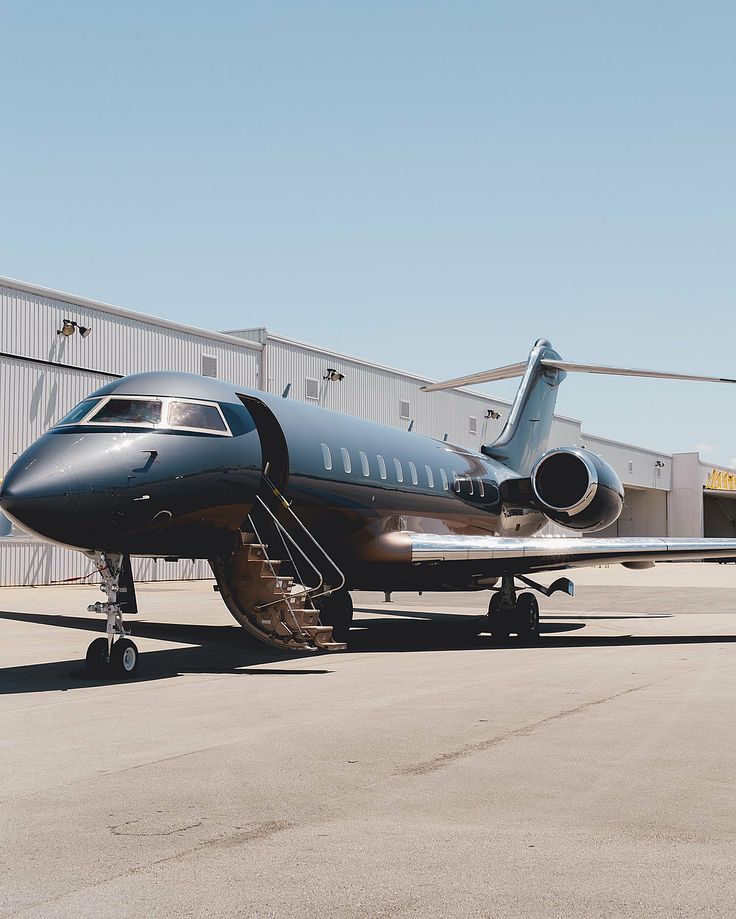 an airplane is parked in front of a hangar