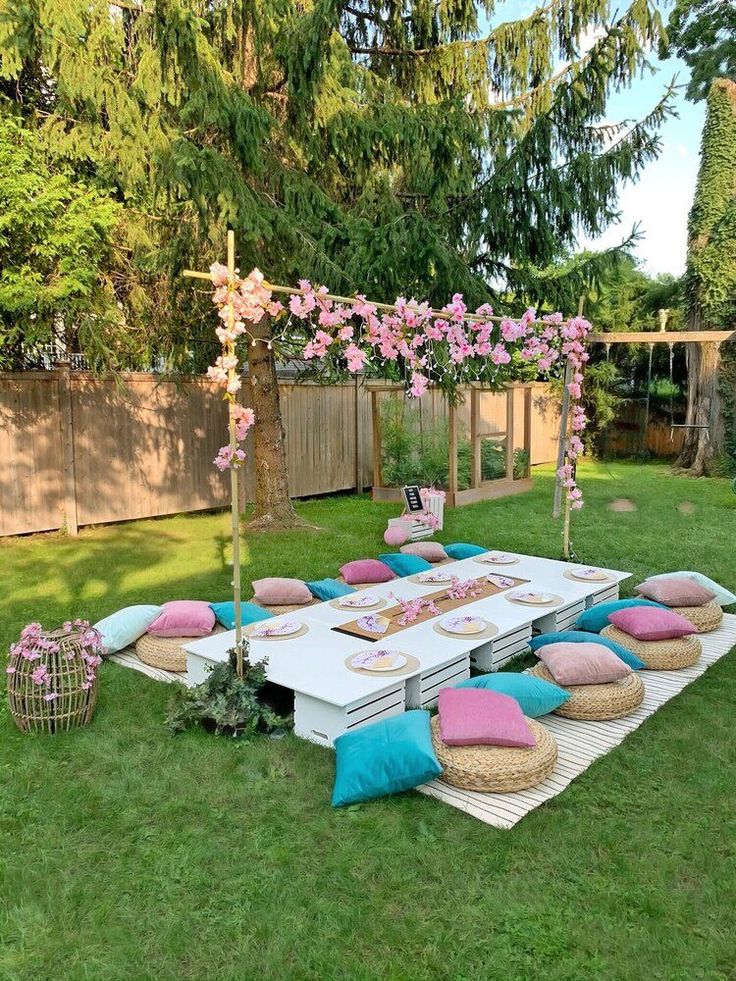 a picnic table set up with pink and blue pillows