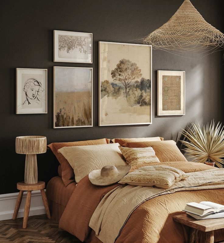 a bedroom with brown walls and pictures on the wall above the bed, along with a lamp