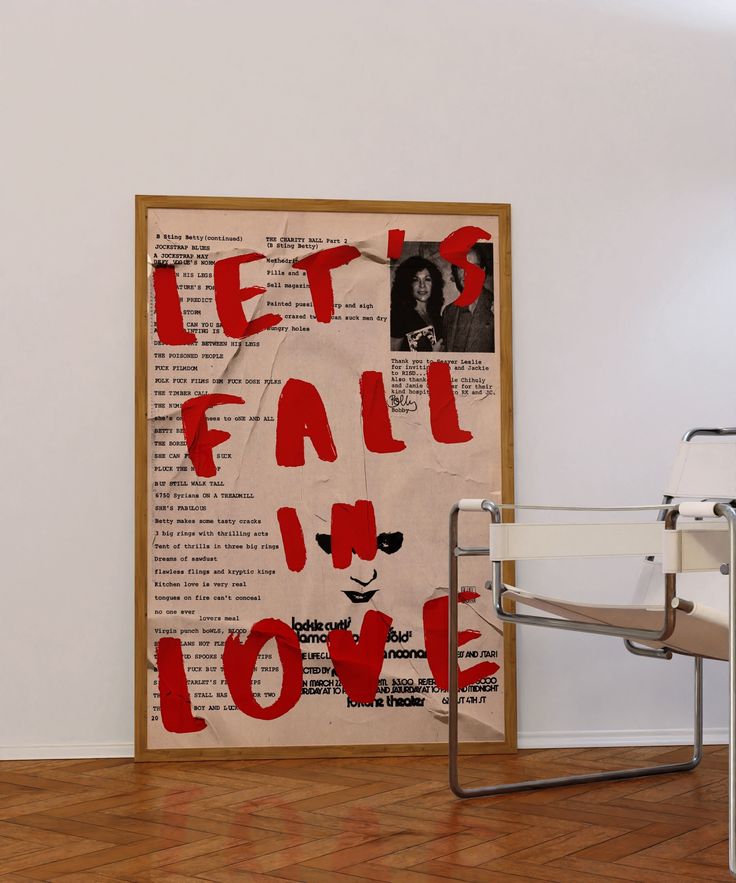 a chair sitting in front of a poster with words on it that read let's fall in love