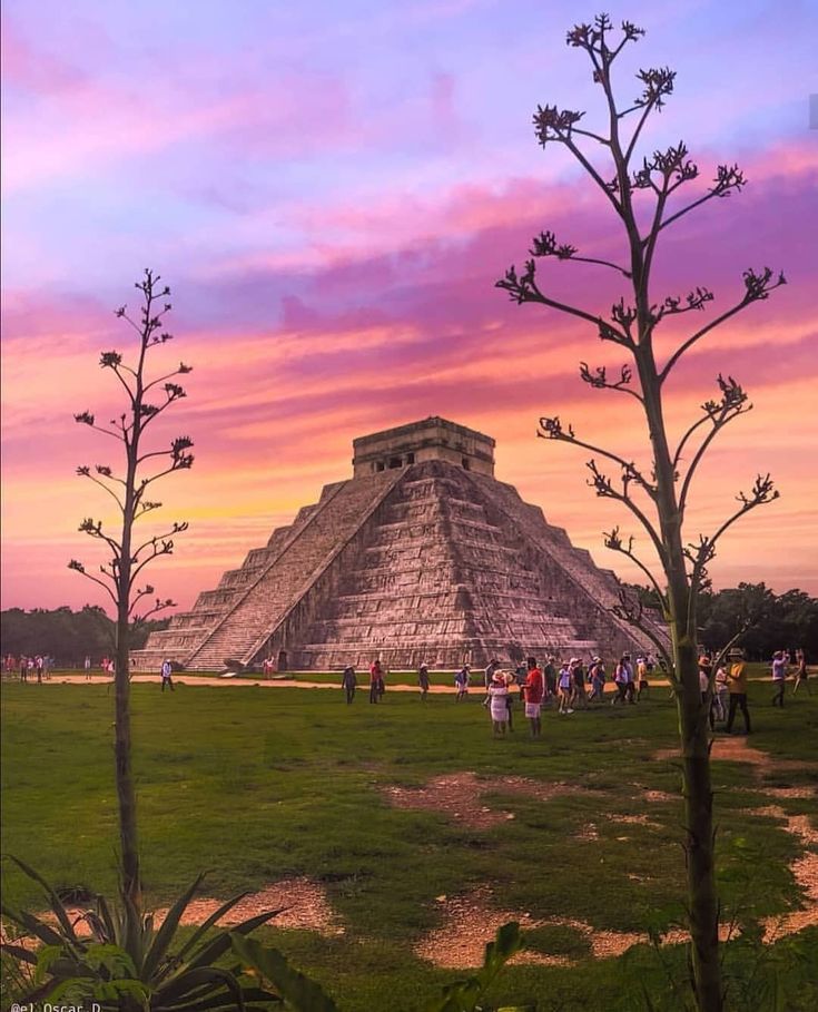 the sun is setting over an ancient pyramid