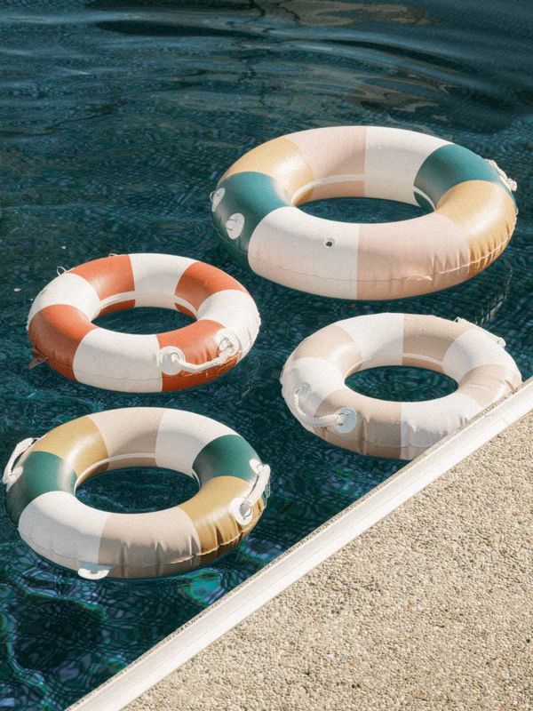 three inflatable rafts floating on top of a pool next to a wall
