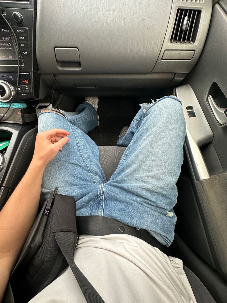 a person laying down in the back seat of a car with their feet on the dashboard