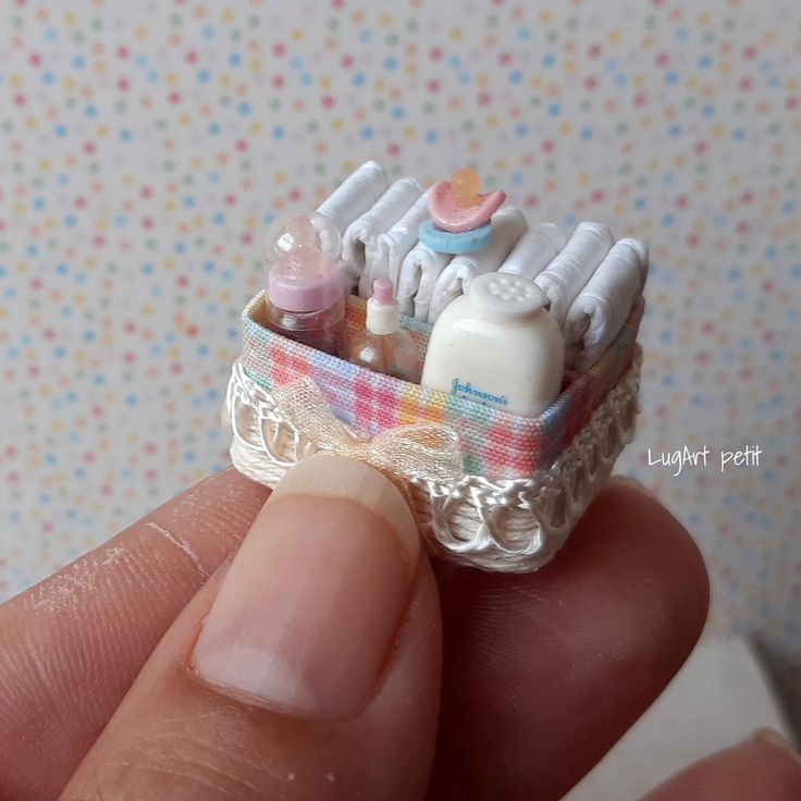 someone is holding a miniature baby's crib made out of toothpaste