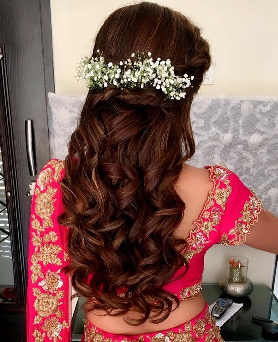 the back of a woman's head with long hair and flowers in her hair