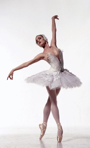 a ballerina in white tutu with her arms extended and one leg bent forward