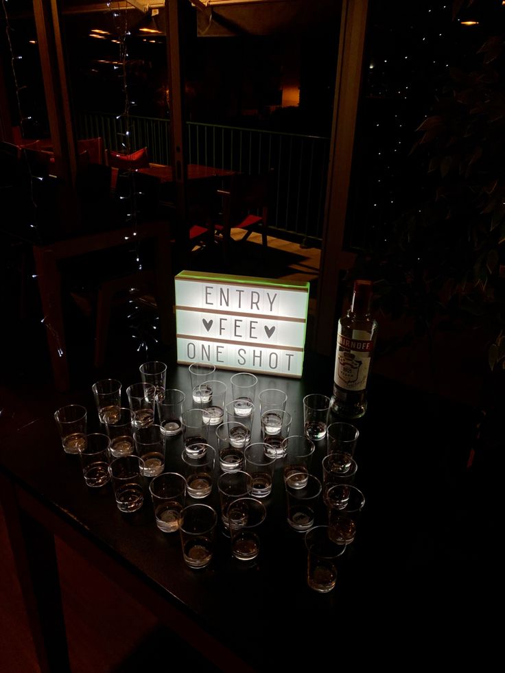 there is a sign that says entry view one shot and many glasses on the table