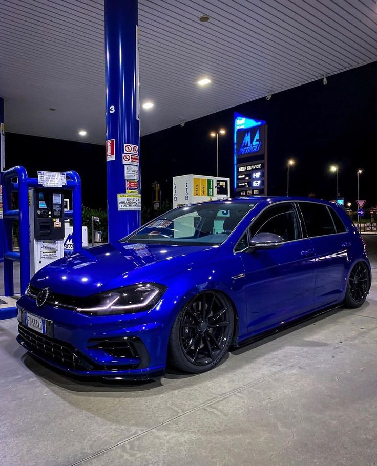 a blue car parked in front of a gas station