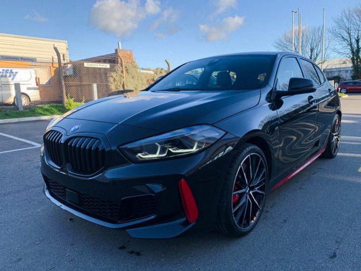 a black bmw car parked in a parking lot