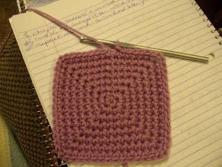 a crocheted square on top of a notebook