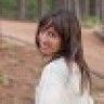 a blurry image of a woman standing in the woods