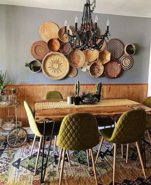 a dining room table and chairs with baskets on the wall above it, in front of a chandelier