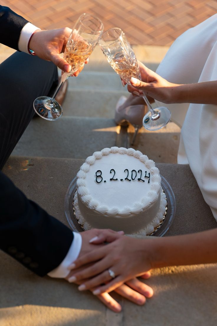 a newly married couple toasting champagne glasses over a cake with the date 2012 on it