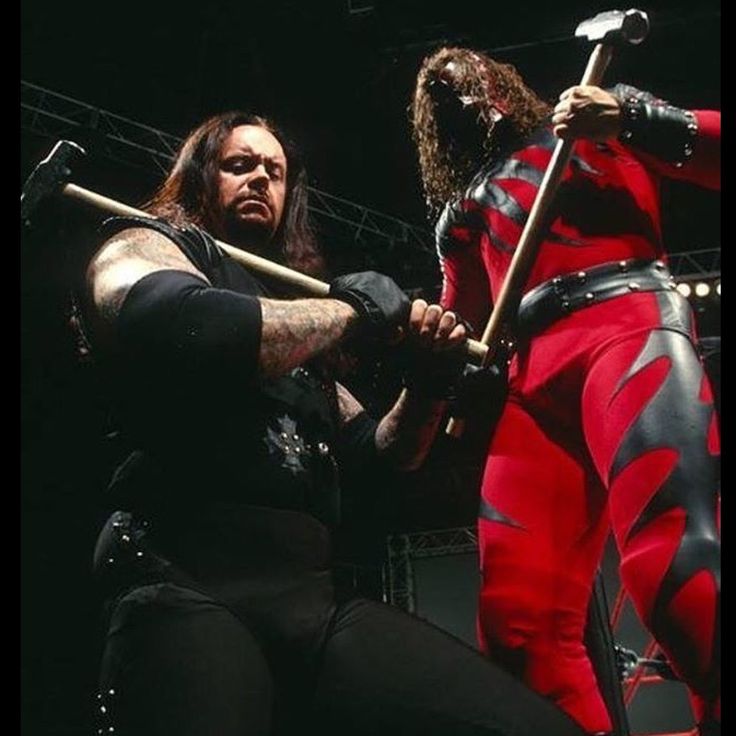 two men in red and black outfits holding swords