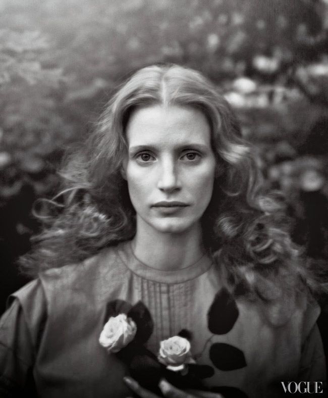 a black and white photo of a woman holding flowers