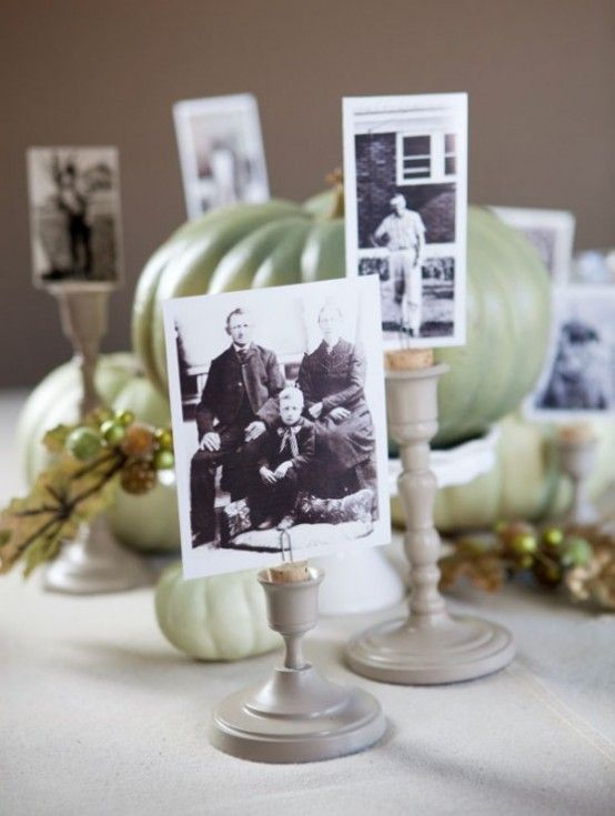 a table topped with pictures and candlesticks on top of a white table cloth